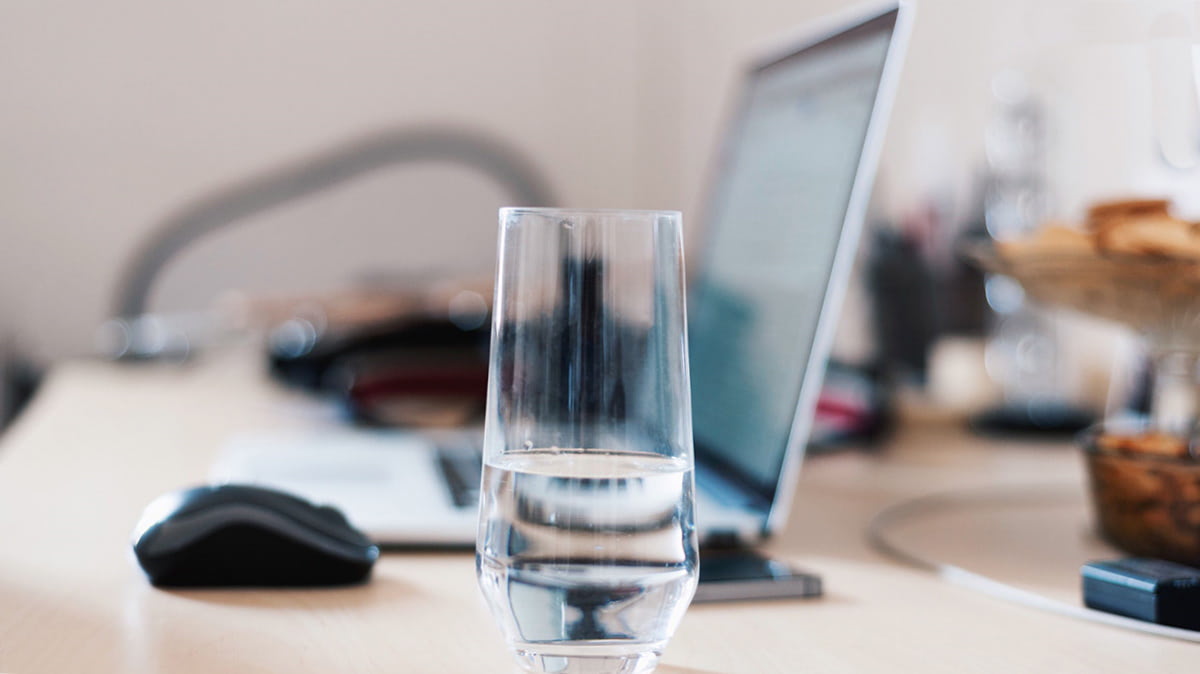 Стакан воды возле ноутбука